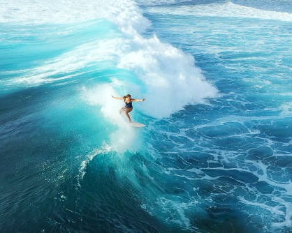 Surfer woman riding on the blue ocean